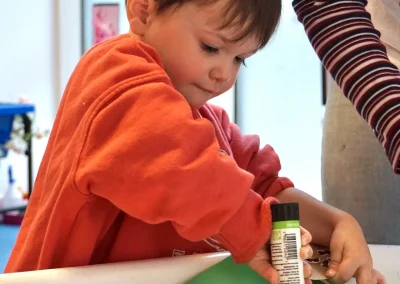Autistic child doing arts and craft, holding a glue stick and applying it on a piece of paper