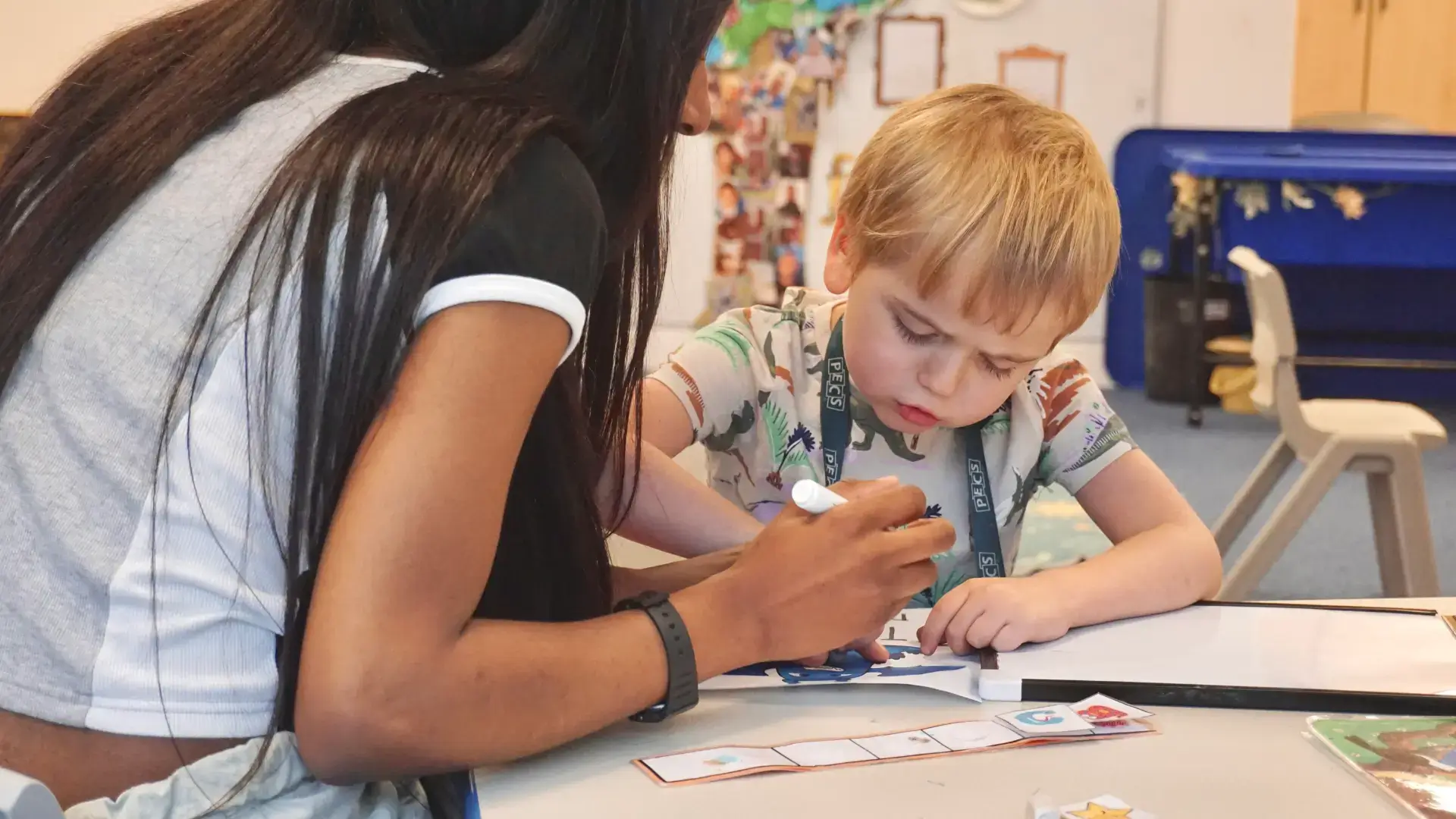 Autistic child at school with therapist learning how to read