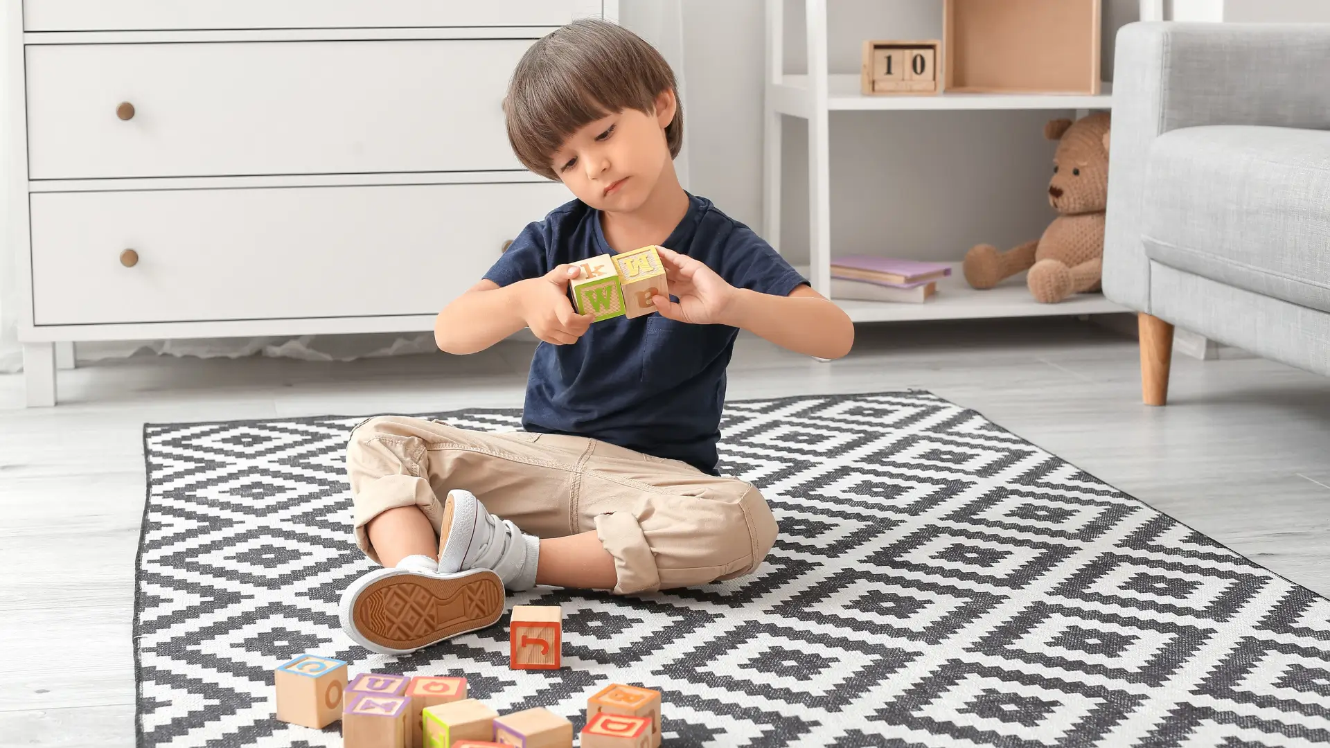 An autistic child playing on his own with cubes and toys