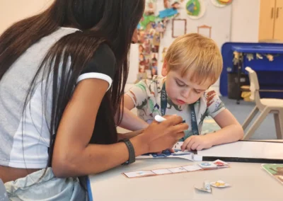 An autistic little boy studying hard and being focused on his task, with the support of his therapist
