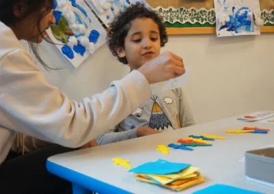 An autistic little boy during therapy at school, identifying numbers and associating them with objects