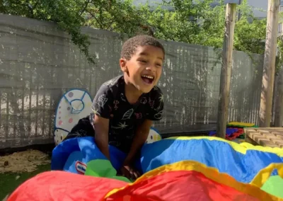 An autistic little boy playing in the garden at school