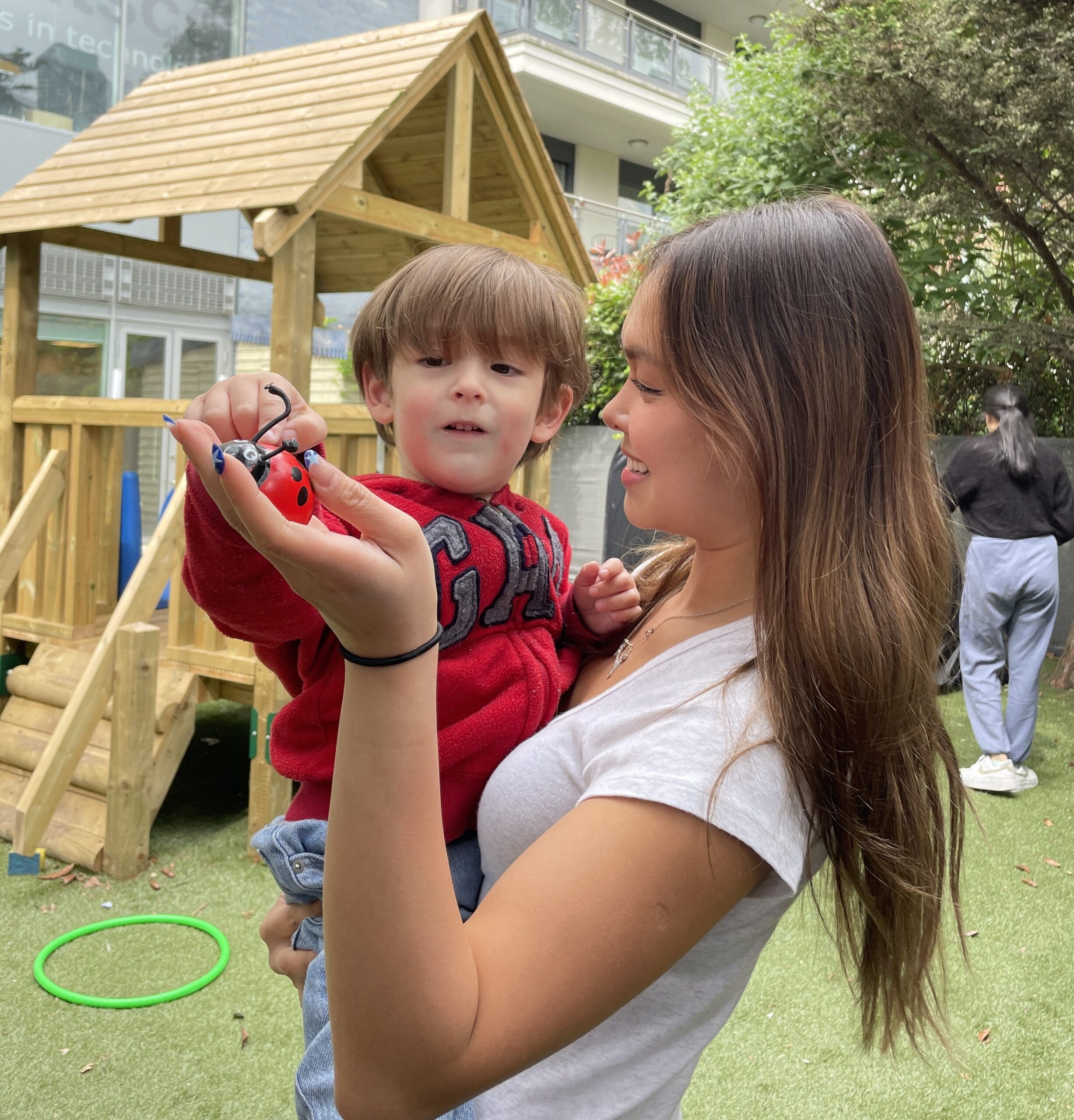 Autistic child excited and smiling at his therapist at a small gathering with bubbles all around him